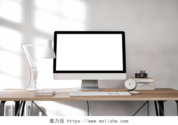 白色房间内桌上摆放台式电脑和日常用品白色空的计算机屏幕与桌灯和书在桌面    